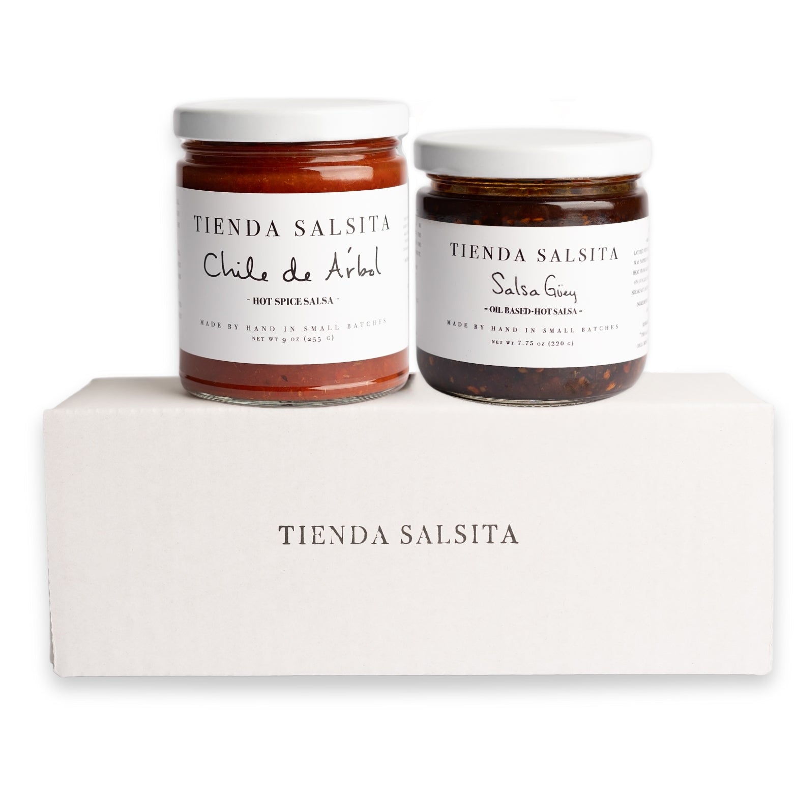 Two jars of Tienda Salsita salsa on a white block with a white background